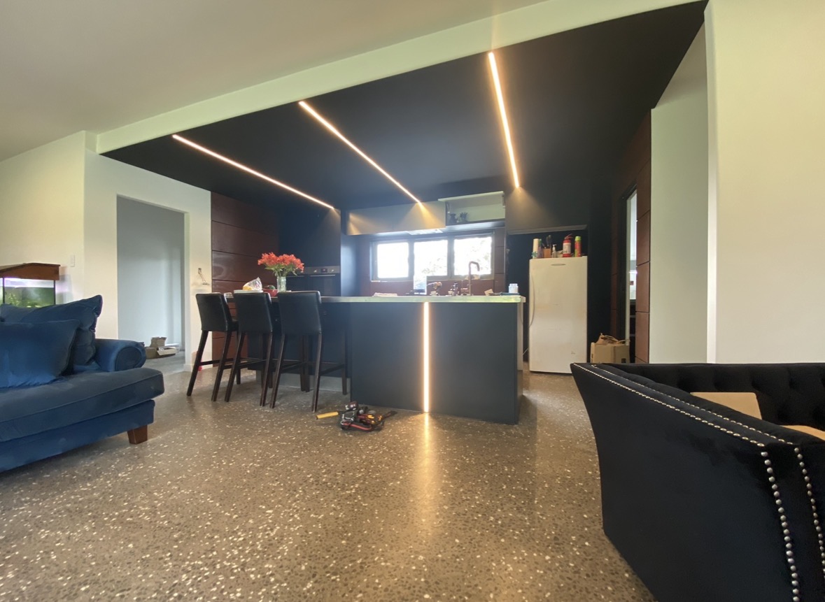 LED strip lighting installation in modern kitchen with dark ceiling and polished concrete floors by Boyd Electrical Whanganui